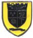 A yellow and black shield with a black logo

Description automatically generated